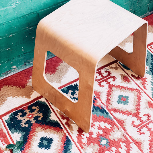 traditional patterned rug with a small stool